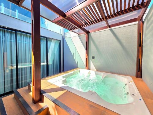 a bath tub in the middle of a room at Sobrado com Jacuzzi Aquecida 10 minutos Centro in Foz do Iguaçu