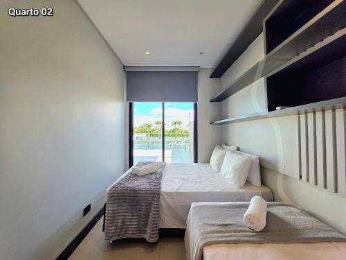 a small bedroom with two beds and a balcony at Sobrado com Jacuzzi Aquecida 10 minutos Centro in Foz do Iguaçu