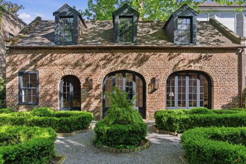 a brick house with bushes in front of it at Gibbon House at Casa Zoe in Charleston