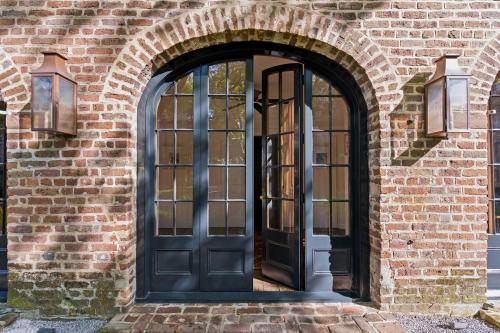 an entrance to a brick building with a black door at Gibbon House at Casa Zoe in Charleston