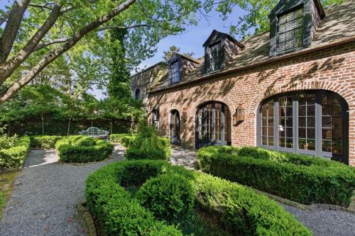 a brick house with bushes in front of it at Gibbon House at Casa Zoe in Charleston