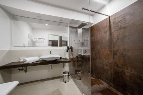 a bathroom with a sink and a glass shower at Riviera Luxury Suites in Naples
