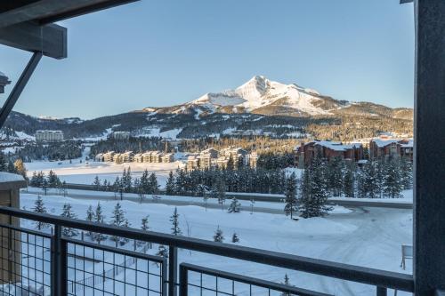a view from the balcony of a resort with a snow covered mountain at Mountain Lake Condo - Unit 401B in Big Sky