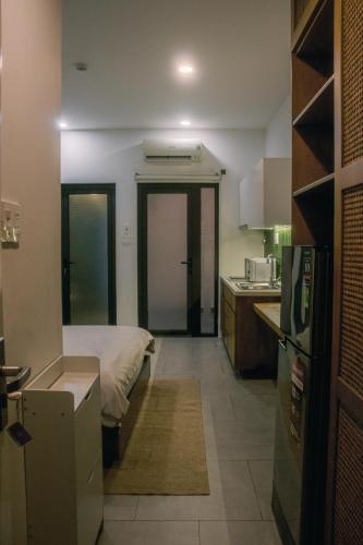 a small kitchen with a bed and a refrigerator at Fair Dinkum Stay District 1 in Ho Chi Minh City