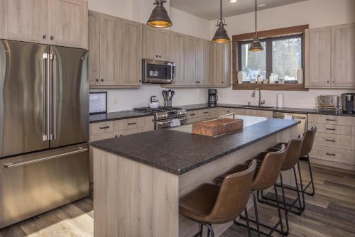 a kitchen with a large island with a refrigerator at Mountain Lake Condo - Unit 502B in Big Sky