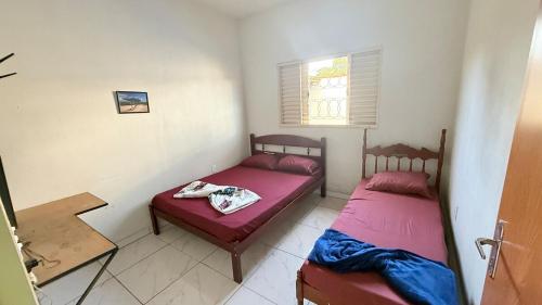 a bedroom with two beds and a window at Recanto Jatobá - Delfinópolis in Delfinópolis