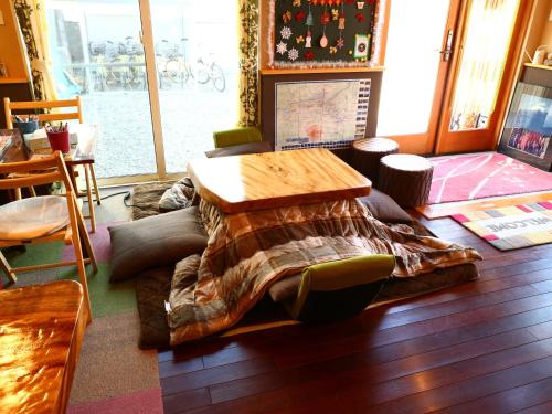 a living room with a table and a couch at ホステル富士山 結 in Fujiyoshida