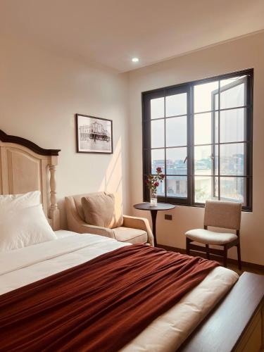 a bedroom with a bed and two chairs and a window at Khách sạn Solea VIỆT TRÌ in Việt Trì