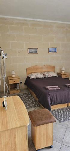 a bedroom with a bed and two tables at Quiet, spacious 3 bedroom 2 bathroom apartment in Għajnsielem