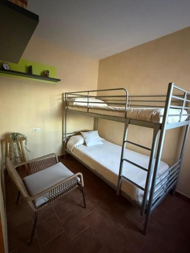 a room with two bunk beds and a chair at Casa Rural La Abejuela in Abejuela