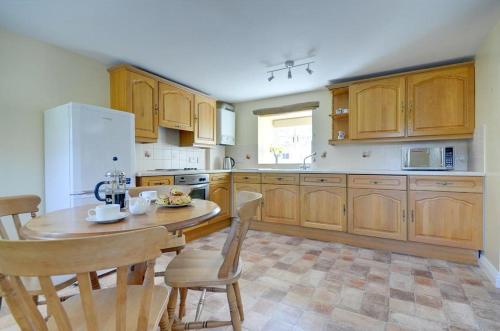 a kitchen with wooden cabinets and a table and chairs at 2 Bed in Pickering oc-y012 in Pickering