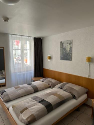 a bedroom with three beds in a room at Chez Gilles Hôtel Restaurant SA in La Chaux-de-Fonds