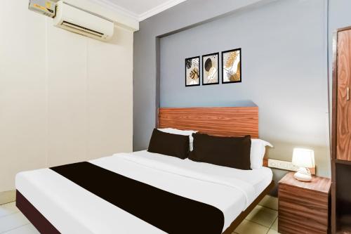 a bedroom with a bed with a white and blue wall at Hotel O Paradise Circle in Hyderabad