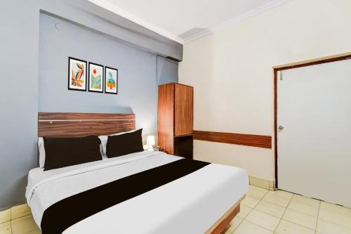 a bedroom with a large white bed in a room at Hotel O Paradise Circle in Hyderabad