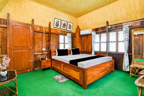 a bedroom with a bed in a room with wooden walls at Super Hotel O Chilapata Forest Formerly Moner Manush Homestay in Uttar Simlabari