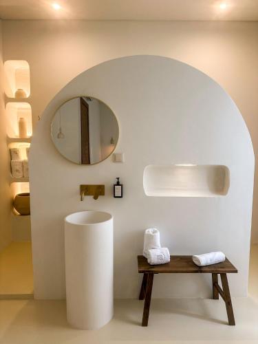 a bathroom with a mirror and a wooden bench at Terracotta House in Porto Santo