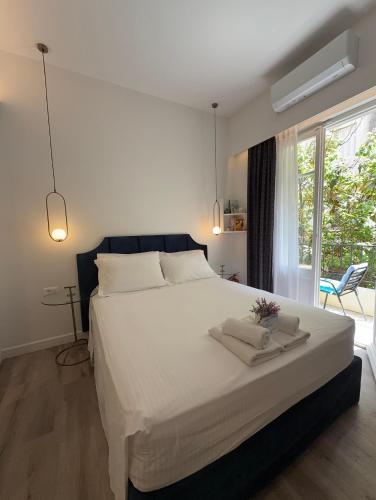 a bedroom with a large white bed and a window at MUSES LUXURY SUITES in Corfu