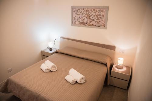 a bedroom with a bed with two towels on it at Suite Prestige Apartment in Torri del Benaco