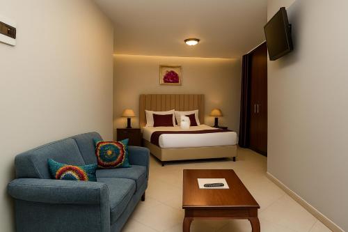 a living room with a bed and a blue couch at Juba Landmark Hotel in Juba