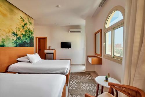 a hotel room with two beds and a window at Palmeras Pyramids Hotel in Cairo