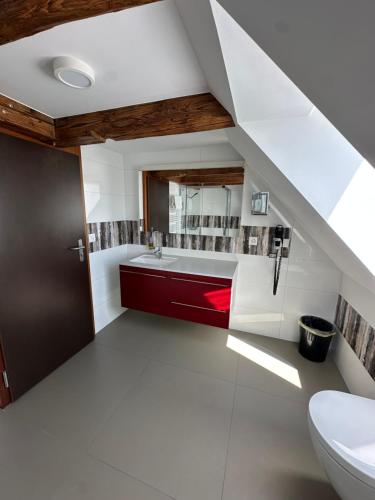 an attic bathroom with a sink and a toilet at Chez Gilles Hôtel Restaurant SA in La Chaux-de-Fonds