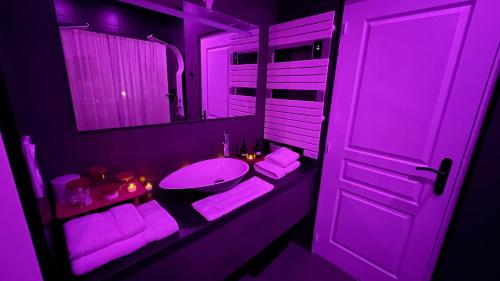 a purple bathroom with a sink and a mirror at Luana SPA Boussois in Boussois