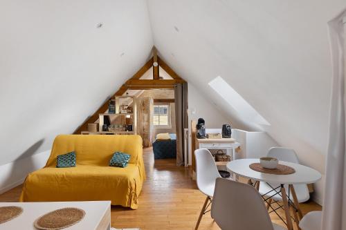 a living room with a yellow bed and a table at La Lizardiere des Landes in La Flèche