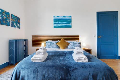 a bedroom with a blue bed with towels on it at Trois Clés Apartment 2 - 2 bed in Eymet
