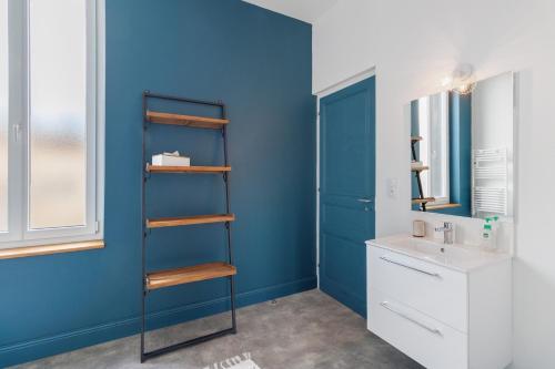 a bathroom with a blue wall and a sink at Trois Clés Apartment 2 - 2 bed in Eymet