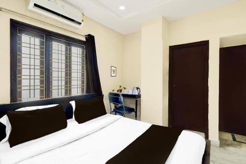 a bedroom with a black and white bed and a desk at Super Collection O Kothapet Near Omini Hospital in Upal
