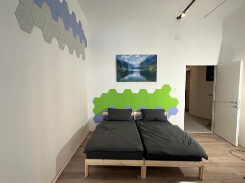 a bedroom with a bed with a green wall at 2 Minunten neben kaiserlichem Park, Zentrumnähe in Vienna