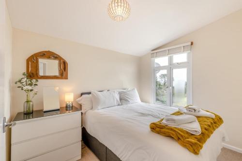 a bedroom with a bed with a dresser and a window at 2 Bed in Stoke Fleming oc-bc777 in Stoke Fleming