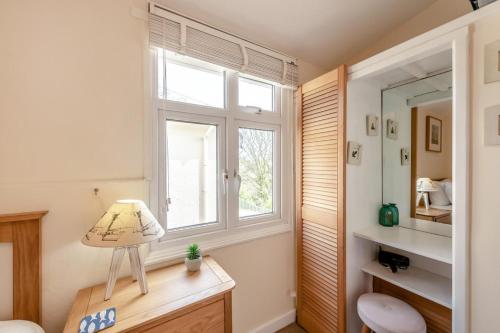 a bathroom with a window and a desk with a lamp at 2 Bed in Stoke Fleming oc-bc777 in Stoke Fleming