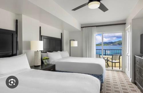 a hotel room with two beds and a balcony at Saint Thomas Villa with Ocean view in Frenchmans Reef Heliport