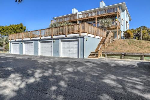a building with three garage doors and a balcony at Sea-Nic View by Oak Island Accommodations in Caswell Beach