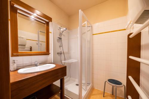 a bathroom with a sink and a shower at Gîte Des Houx in Le Soulié