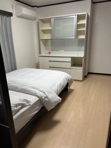 a bedroom with a bed and a desk and a television at Hanako-Home in Fukuoka