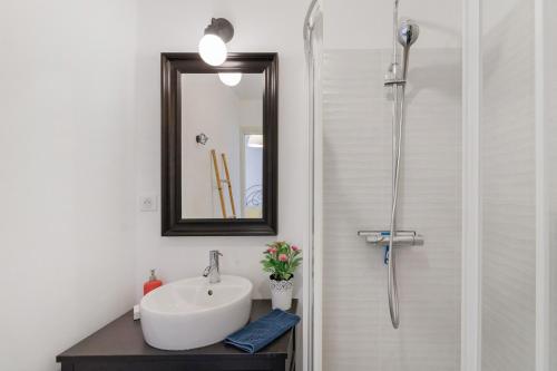 a bathroom with a sink and a mirror and a shower at Stagnolo in Porticcio