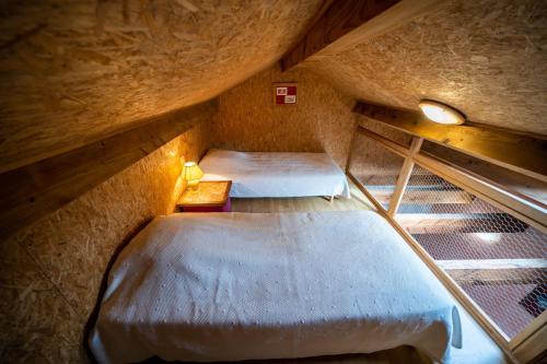 a room with two beds in a attic at Gîte Des Myrtilles in Le Soulié