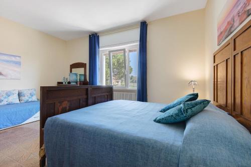 a bedroom with a blue bed and a window at Apartment Celeste - Isola D'elba in Portoferraio