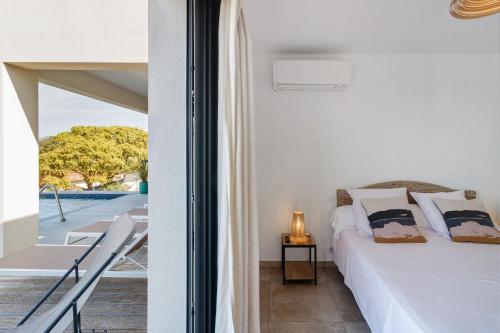 a bedroom with a bed and a view of a pool at Stagnolo in Porticcio