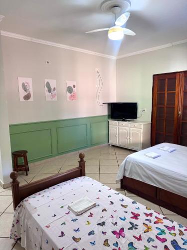 a bedroom with two beds and a flat screen tv at Quarto suíte privativo em campinas para até 3 pessoas in Campinas