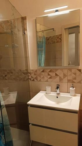 a bathroom with a sink and a mirror and a shower at Perla di mare in La Maddalena