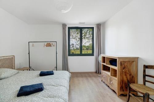 a white bedroom with a bed and a window at Gite Les 3 Tilleuls in La Ville Dieu du  Temple