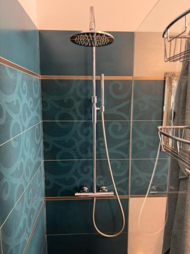 a bathroom with a shower with blue tiles at B&B Perbacco Relax in Mezzolombardo