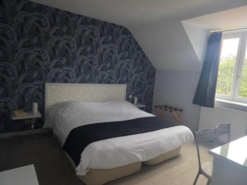a bedroom with a bed with a patterned wall at Logis Hotel Restaurant La Marjolaine in Moulay