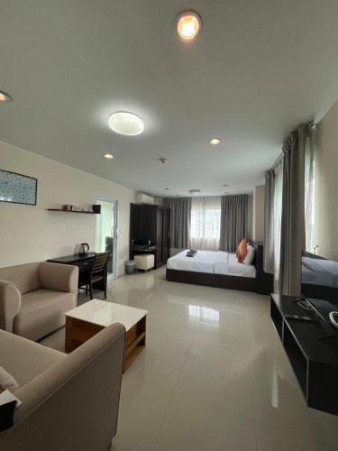a large living room with a bed and a couch at Patt Serviced Apartments in Chon Buri