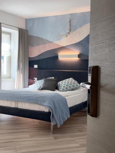 a bedroom with a bed with a painting on the wall at B&B Perbacco Relax in Mezzolombardo