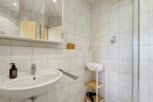 a white bathroom with a sink and a mirror at Apartment mit Gartenblick K1 201 in Spalt