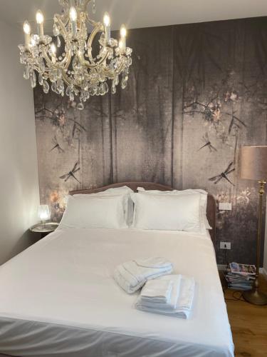 a bedroom with a chandelier and two towels on a bed at squero 911 appartament in Cesenatico